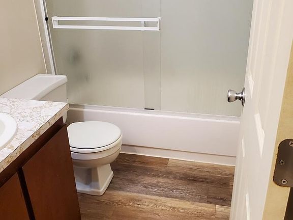 This is a photo of the bathroom, which shows the nice Bathroom vanity as well as the newer bathroom floor, and nice glass shower slider doors.