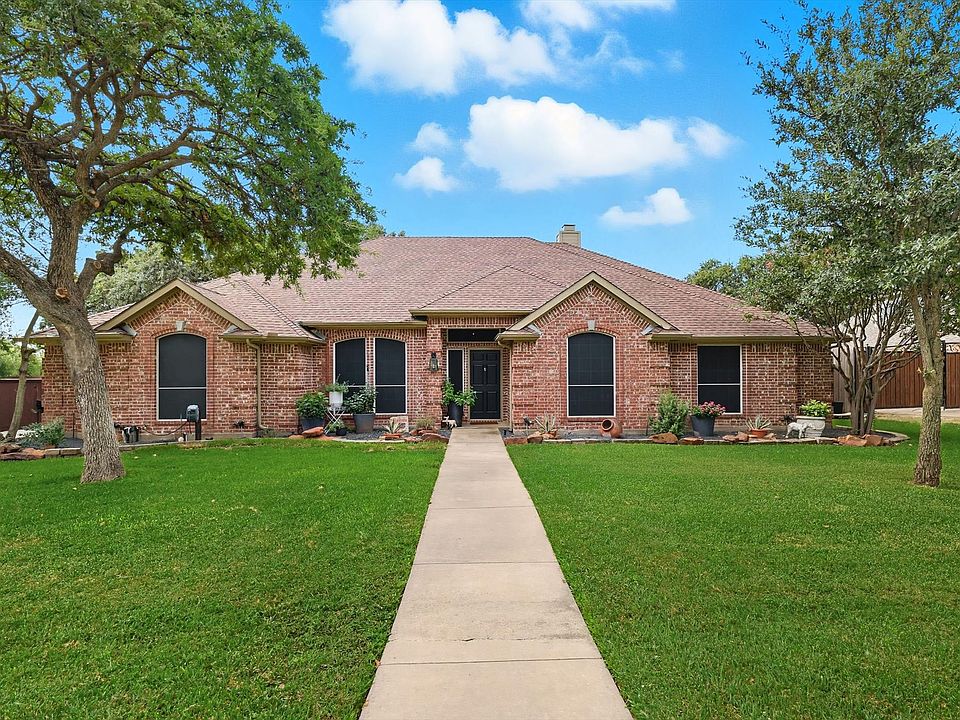 Beautiful ranch-style house with roof with shingles, brick siding, and a chimney