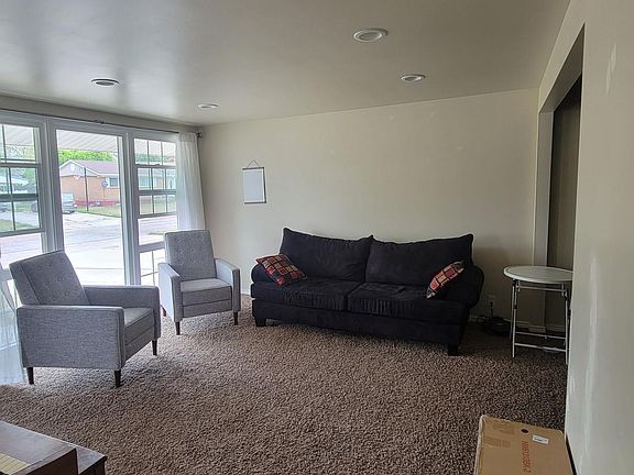 Living room facing front of house. Large windows bring in natural light and open for an amazing cross breeze!