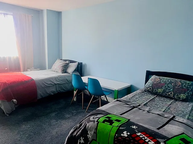 Bedroom #2: Twin beds, Ceiling fan, Flat screen TV w/ Fire-stick, Dresser, Table w/ 2 chairs, Bookshelf, Spacious closet, Black-out curtains.