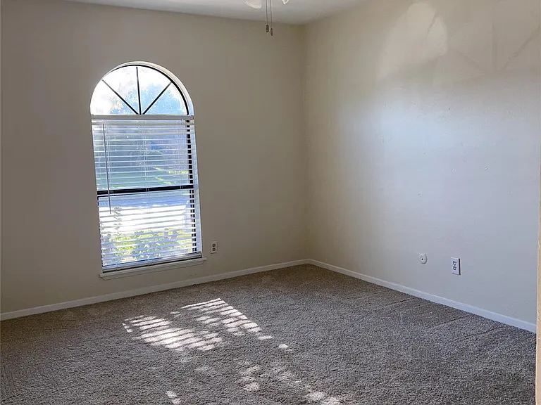 Carpeted empty room with ceiling fan