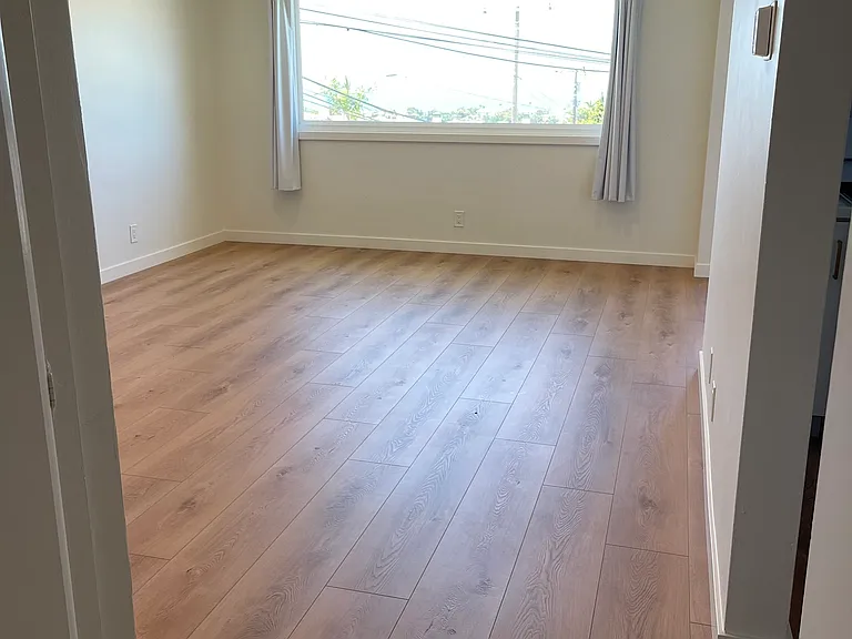 View from hallway from smaller bedroom going into living room.