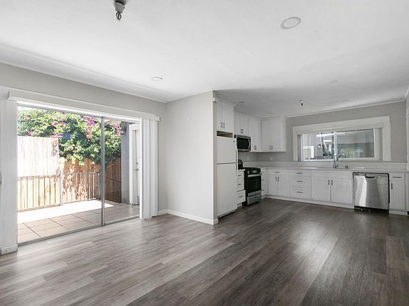 Living room looking into dining area and kitchen. Slider to private patio on the left
