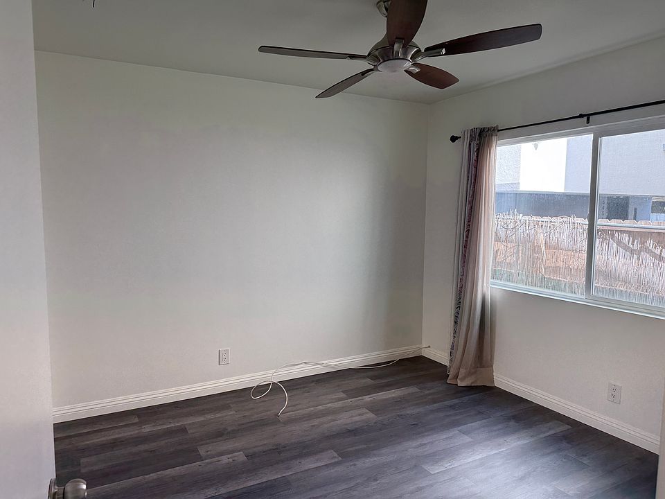 Bedroom with new floor and paint, large window, and ceiling fan