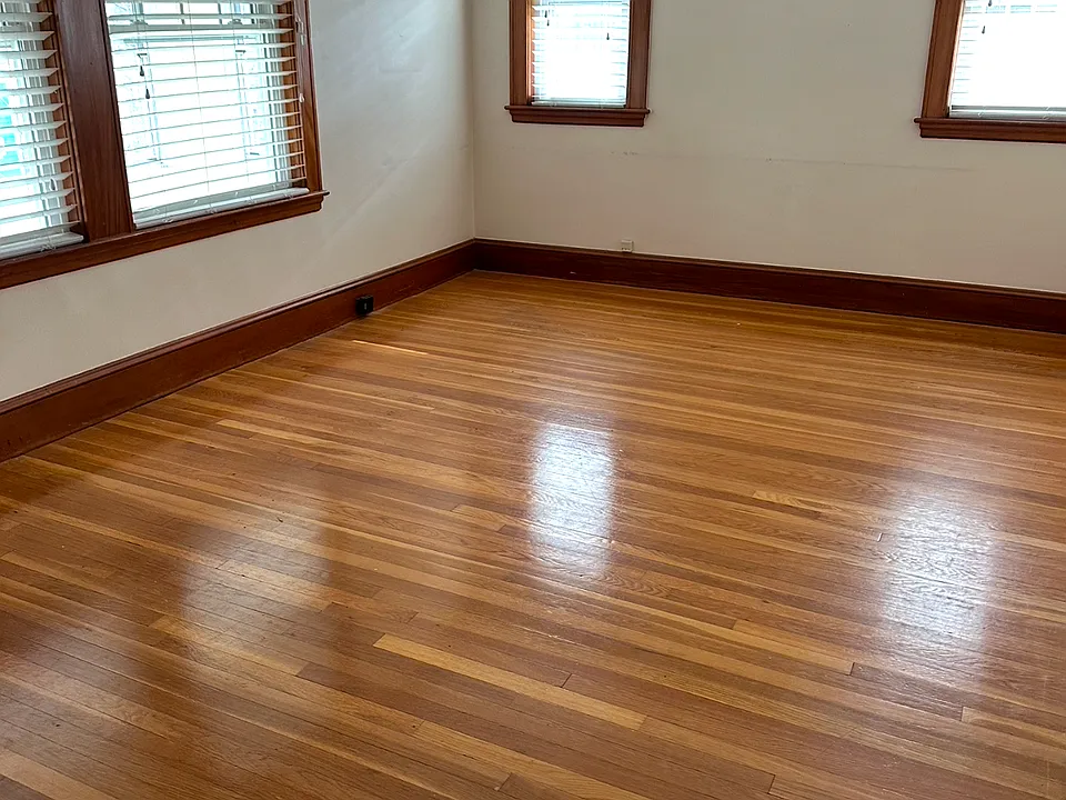 Living room with an abundance of natural light throughout with gleaming hardwood floors.