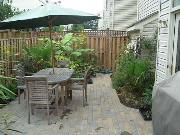Gorgeous designer brick patio enclosed by a privacy fence