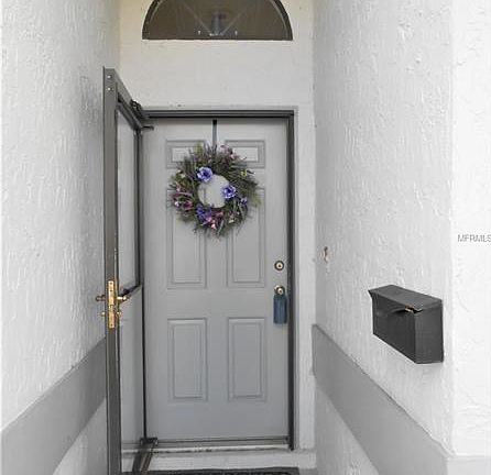 Covered entry with a storm door and fan window above to let in light.