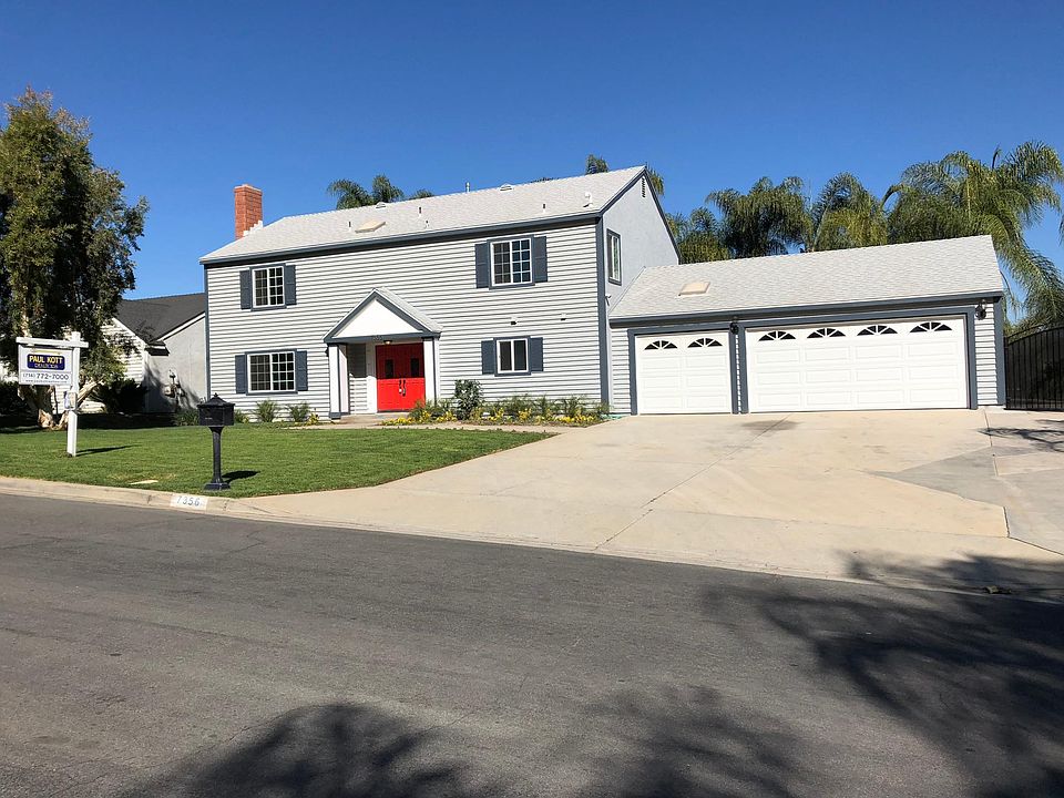 Front of house, RV parking at far right behind black wrought