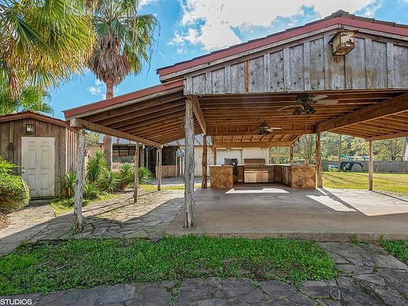 Outdoor kitchen with grill and sink located next t