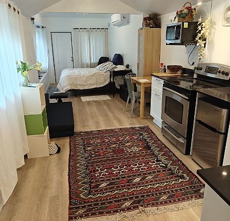 View from rear of cottage (full size bed and carpets for display purposes only and not included in rental).