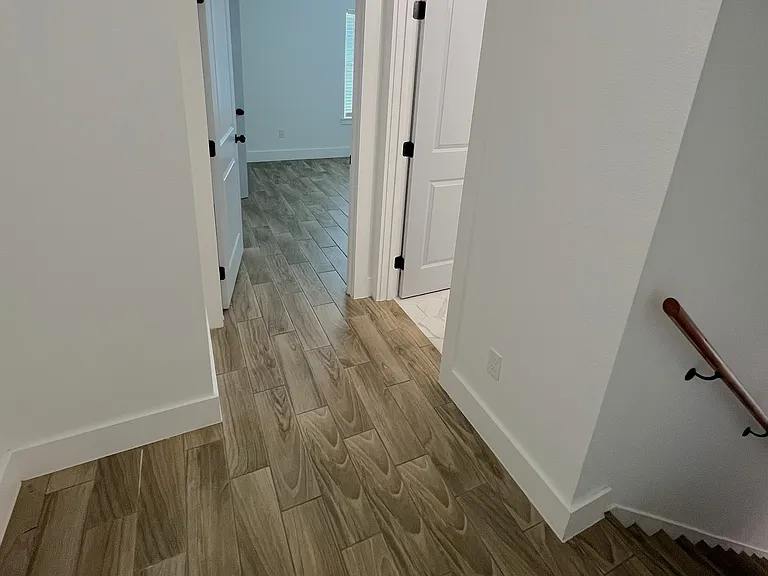 Upstairs. Stairs (right), full bathroom (center right), bedroom #1 (center left), bedroom #2 (left)