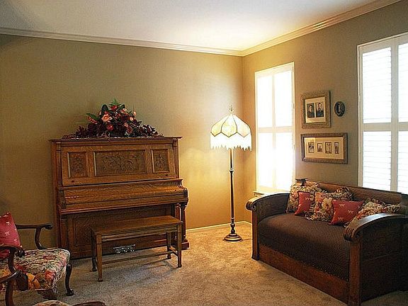 Formal living room with Plantation shutters, recent carpet & paint.