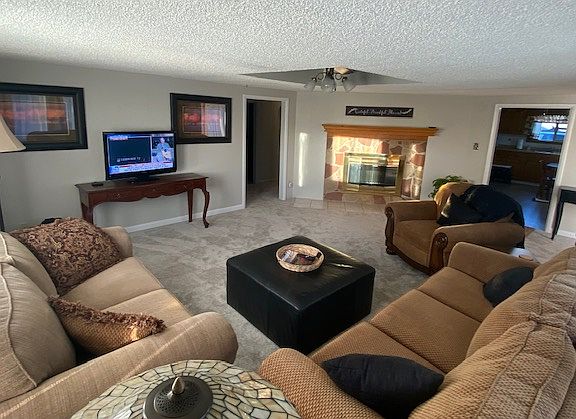 Large, comfortable living room with electric fireplace.
