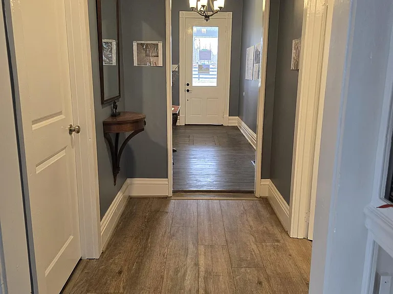 View of main hallway from kitchen to front door - full guest bath, two bedrooms are located off of this hallway.