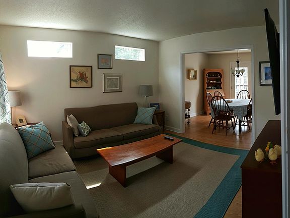 Living room transom windows fill the room with sunlight with views of the sky and tree tops, but no loss of privacy and wall space. The large composite deck is beyond the dining room through French doors.