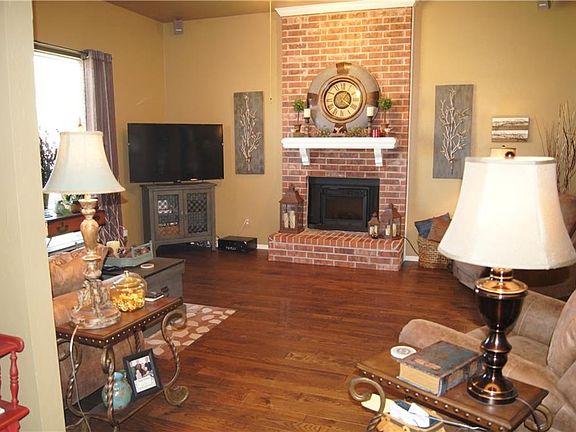 Beautiful wood floors, brick fireplace and large window overlooking front yard