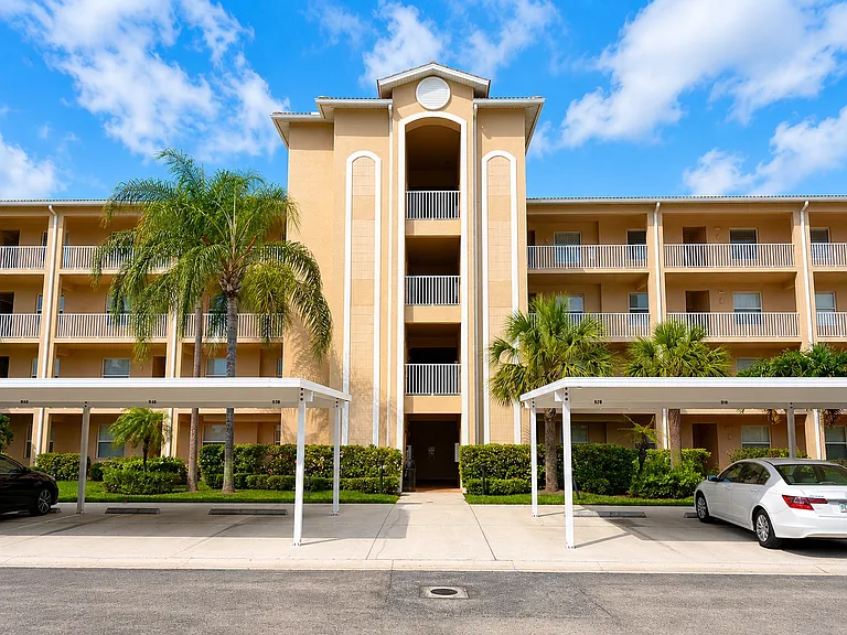 Elegant Mediterranean-style building with covered parking and lush palms