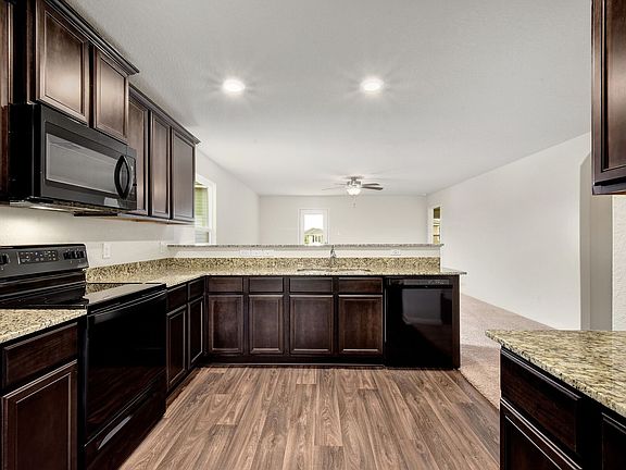 The kitchen features granite countertops and stunning wood cabinetry