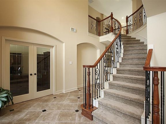Designer tiled entry with a curved front staircase. To the left through the double doors you will find the study/office.