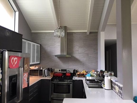 Modern Stainless Kitchen, including Gas Range, and Quartz Countertops, from Dining Room Perspective