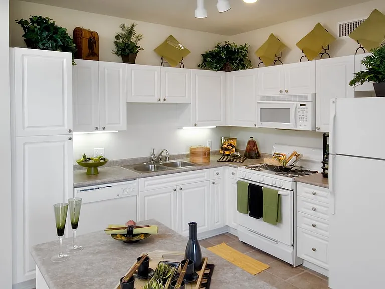 Classic Package I kitchen with island featuring white cabinetry, white appliances, laminate countertops, and tile flooring