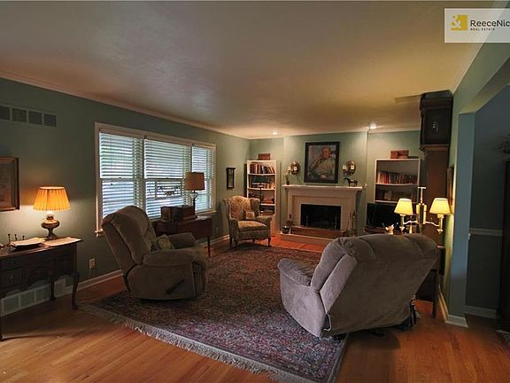 Lovely Living Room has Brick Fireplace with gas logs and hardwood floors