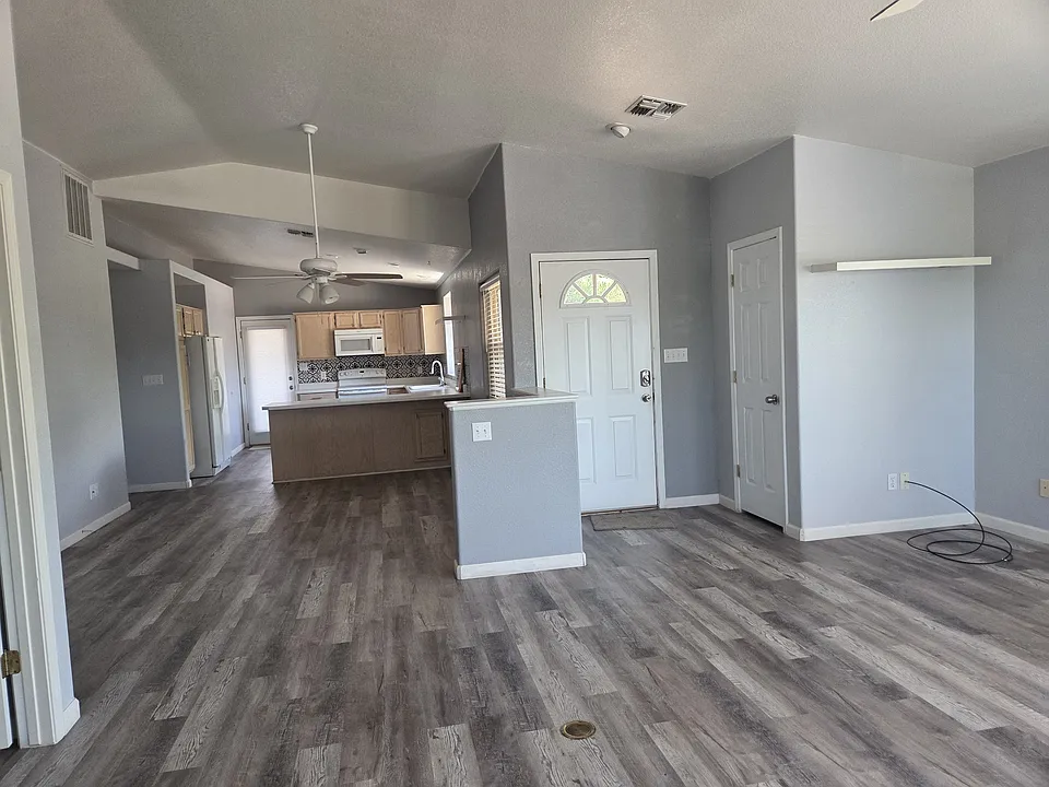 Photo from the living room through the dining room into the kitchen. Front door and spacious coat closet.