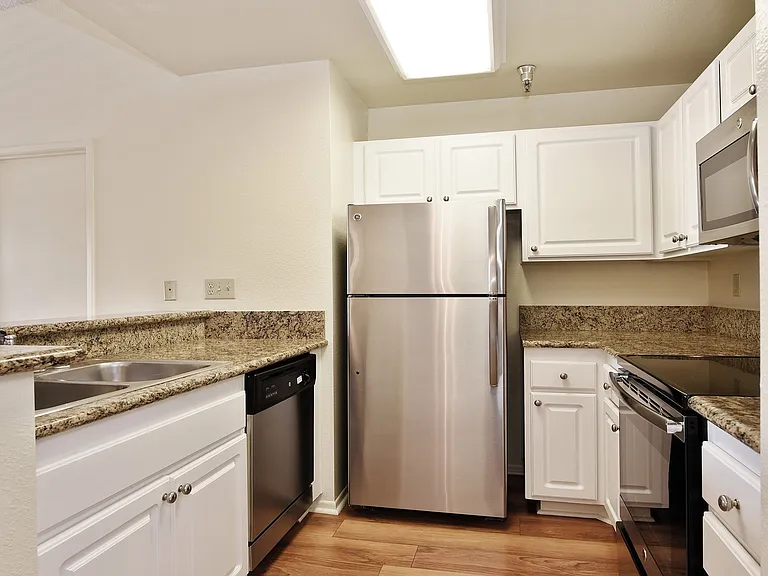 Kitchen with granite countertops, stainless steel appliances and a breakfast bar