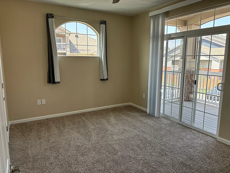 Second bedroom with attached patio, walk in closet, and bathroom