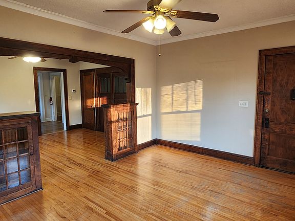 View of the LR, door to apartment (right) and DR (left). Note nine foot high ceilings, ceiling fan/light, builtin bookcases, vintage 1920's woodwork and maple floors.