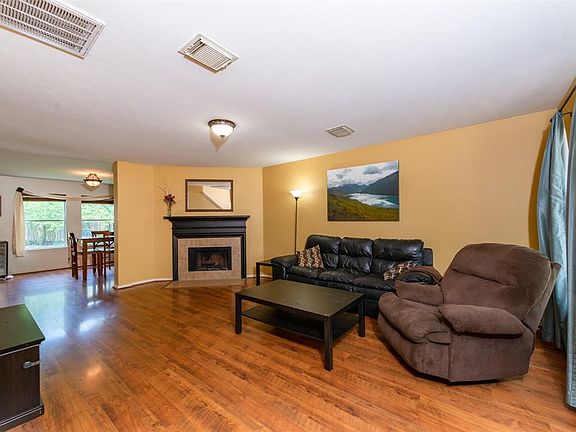 The family room features care-free wood look laminate flooring, a fireplace with tile surround and wood trimmed mantle.