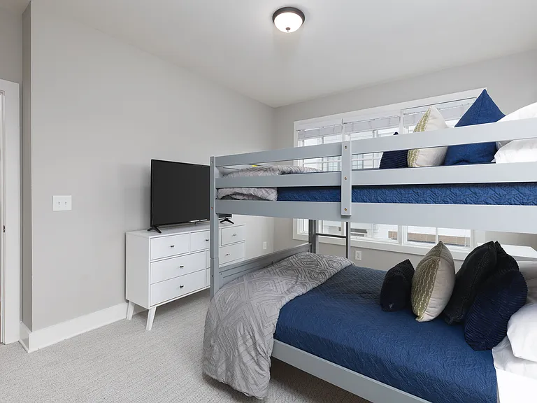 Bedroom 3 with a bunk bed, ensuite bathroom, Smart TV and dresser for your belongings. Also includes a walk-in closet. Located on the 2nd floor.
