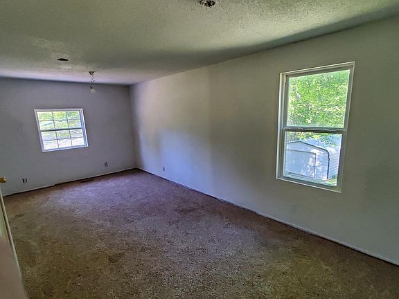 LARGE rear bedroom. ~12ftx24ft. Walls will be painted the gray color. Ceiling fan with lights to be installed. 2 individual swing door closets are on the left side of this picture.