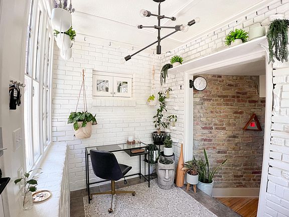 Endless exposed brick and a step down entrance to the rest of the living area