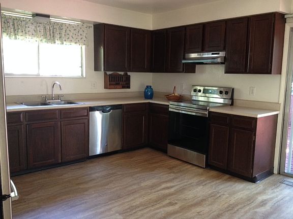 Kitchen with sliding glass doors to huge porch on right. Pretty tree views out the kitchen window onto front garden.