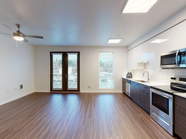 Apartment Kitchen with Stainless Steel Appliances, Dining and Living Room with Wood Style Flooring and Patio/Balcony.