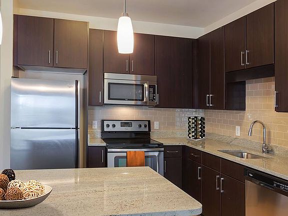 Open concept kitchen with granite countertops, stainless steel appliances, tile backsplash and kitchen island