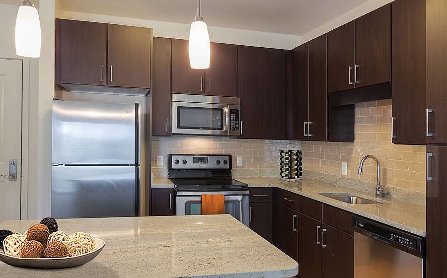 Open concept kitchen with granite countertops, stainless steel appliances, tile backsplash and kitchen island