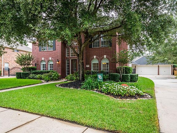 Home features beautiful oak trees and three car detached garage with additional parking.