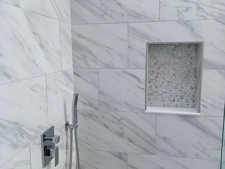 Notice the attention to detail . New special order double shower head fixture, Carrara marble walls , accent shower niche and floors coordinating color matching ceramic pebble tile render this shower the WOW effect. NO THIS IS NOT YOUR COMMON RENTAL PRO