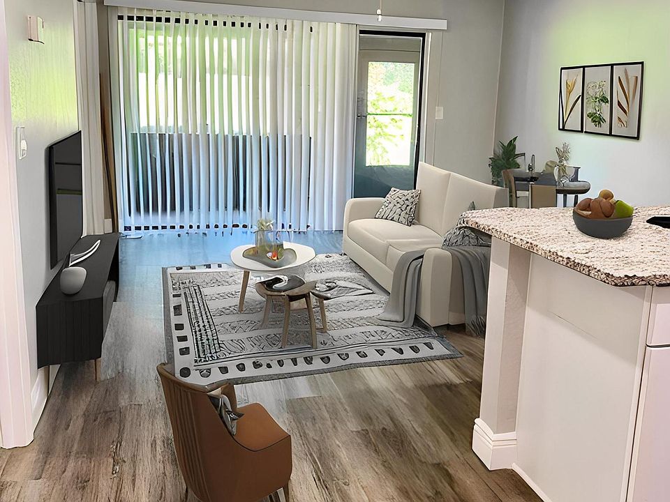 Open concept living room & kitchen, with enclosed patio.