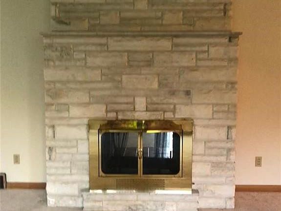 Beautiful floor to ceiling Stone Fireplace Graces Entertainment Living Room.