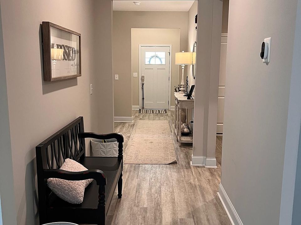 Hallway leading to front door, front bedrooms and full bathroom on the left. Garage, laundry and visitor bathroom on the right.