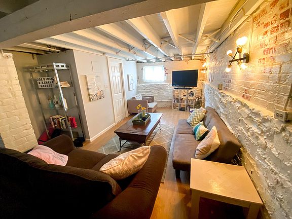 Spacious living room with stone/brick walls