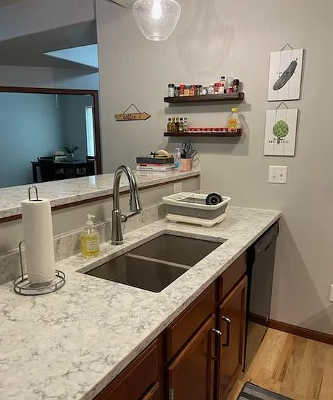 Newly remodeled kitchen with quartz countertop, granite sink and modern faucet