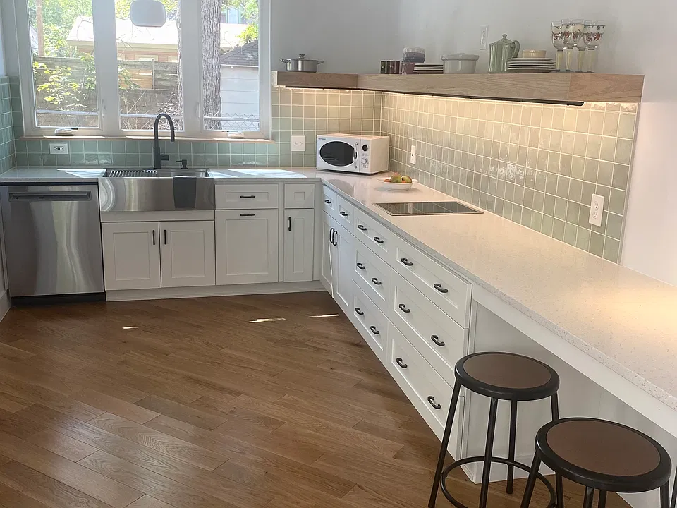 CRAFTSMAN TILE BACKSPLASH, CUSTOM LIGHTING, STAINLESS APPLIANCES AND HAND BUILT COUNTER SHELVING. SOUTHERN LIGHT TO OPEN GARDEN WITH HUGE TREE.