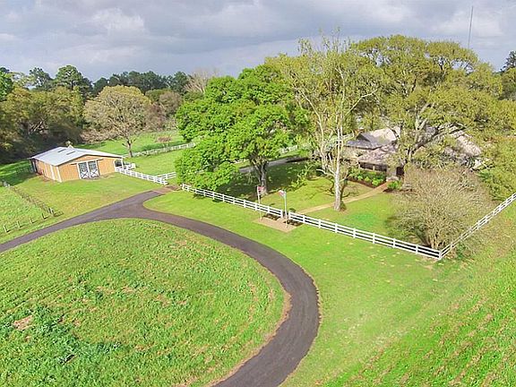 Property is unrestricted with horses set up including barn with beautiful horse stalls and attached PVC fenced paddock.