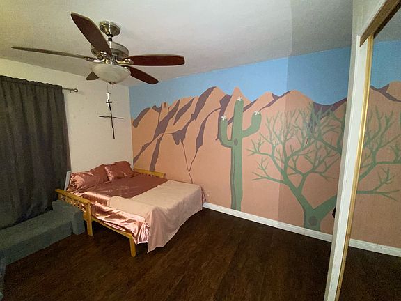 Bedroom with queen sized bed and hand painted mural of the Catalina Mountains