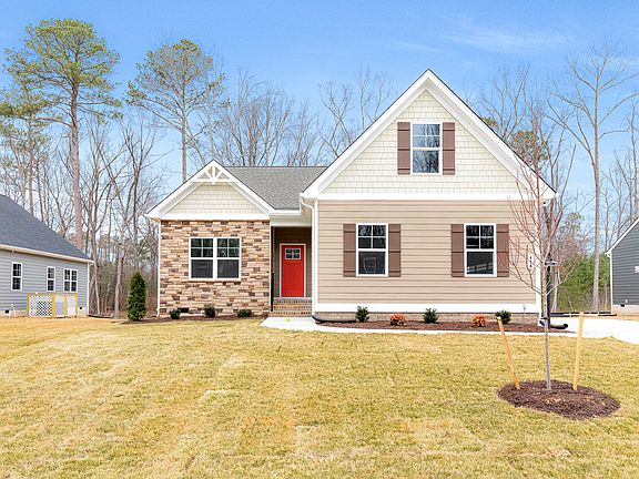 Single-story Somerset Hill house with beige siding, red door, front lawn, and clear blue sky.