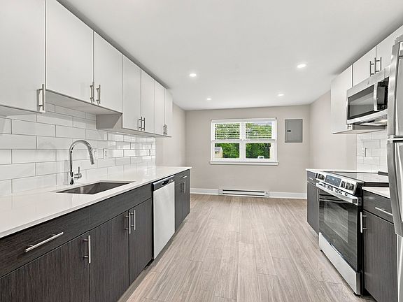 Brand new kitchens with stainless steel appliances and custom tile backsplash